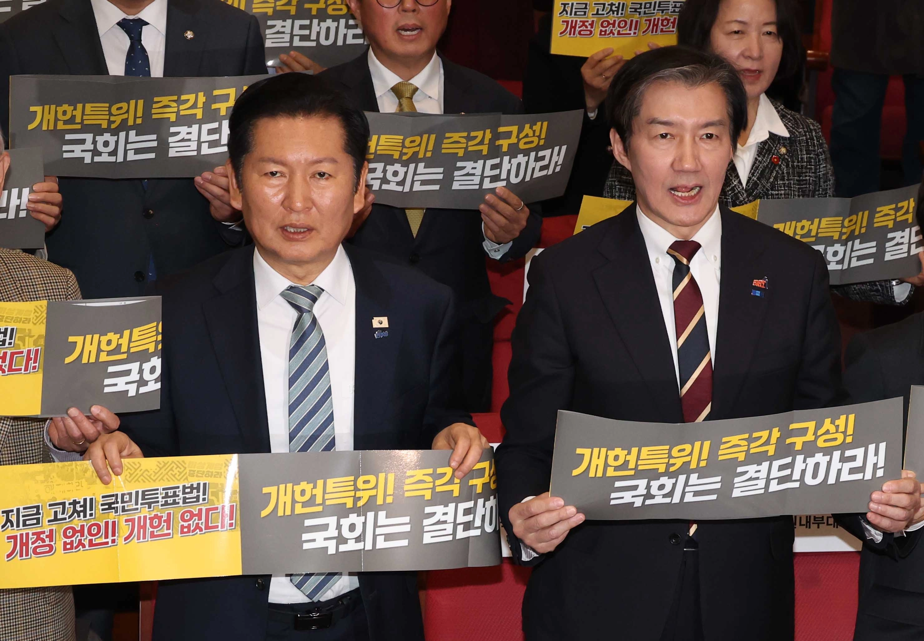 정청래(왼쪽) 더불어민주당 대표와 조국 조국혁신당 대표가 지난달 25일 국회 의원회관 대회의실에서 열린 5·18정신 헌법전문수록 개헌 촉구 국민결의대회에서 손피켓을 들고 구호를 외치고 있다. 뉴시스