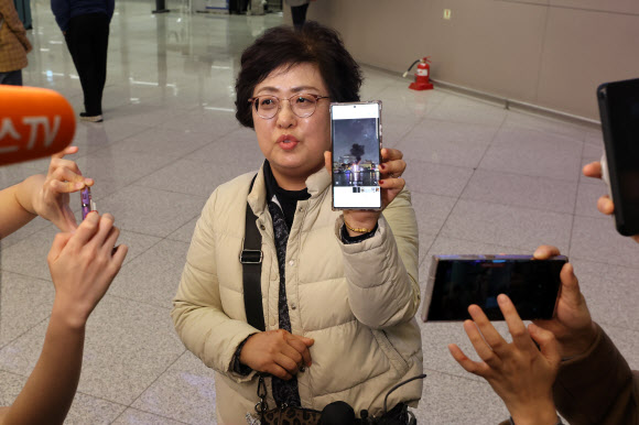 중동을 방문했다 귀국한 한 여행객이 5일 인천국제공항에서 중동 현지에서 찍은 사진을 보여주며 취재진과 인터뷰하고 있다. 2026.3.5 연합뉴스