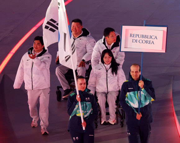 6일(현지시간) 이탈리아 베로나 아레나에서 열린 2026 밀라노·코르티나 동계패럴림픽 개막식에서 국기를 든 자원봉사자와 대한민국 선수 및 임원진이 입장하고 있다. 오는 15일까지 열흘간의 열전에 돌입하는 이번 대회에는 56개국에서 역대 최다인 612명의 선수가 참가해 79개의 금메달을 놓고 격돌한다. 2026.3.7  연합뉴스