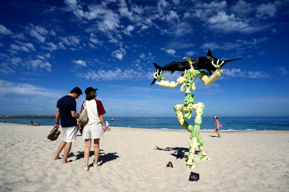 해변 방문객들이 9일(현지시간) 호주 퍼스 코테슬로 해변에서 열린 ‘바닷가의 조각’ 전시회에서 제이슨 크리스토퍼의 설치 작품 ‘Ode to the Ancestors’를 감상하고 있다. AFP 연합뉴스