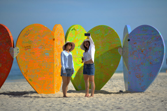 해변 방문객들이 9일(현지시간) 호주 퍼스 코테슬로 해변에서 열린 ‘바닷가의 조각’ 전시회에서 제이슨 허스트의 설치 작품 ‘Love U’ 앞에서 사진을 찍고 있다. AFP 연합뉴스