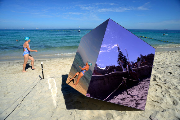 해변 방문객이 9일(현지시간) 호주 퍼스 코테슬로 해변에서 열린 ‘바닷가의 조각’ 미술 전시회에서 앤드류 파머의 설치 작품 ‘Homage to the Cube’을 지나 가고 있다. AFP 연합뉴스  