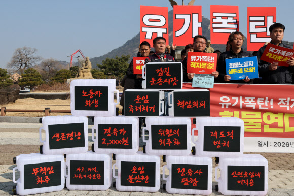 화물연대 조합원들이 12일 서울 청와대 사랑채 앞에서 열린 유가폭등 적자운송-경유값 폭등 대책 마련 촉구 회견에서 구호를 외치고 있다. 2026.3.12 연합뉴스