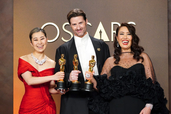 매기 강(왼쪽부터) 감독, 크리스 아펠한스 공동 연출자, 미쉘 L.M.웡 프로듀서가 15일(현지시간) 미국 캘리포니아주 로스앤젤레스 돌비 극장에서 열린 ‘제98회 아카데미 시상식’에서 케이팝 데몬 헌터스(케데헌)로 장편 애니메이션상을 수상한 후 프레스룸에서 기념 촬영하고 있다.  AP 연합뉴스