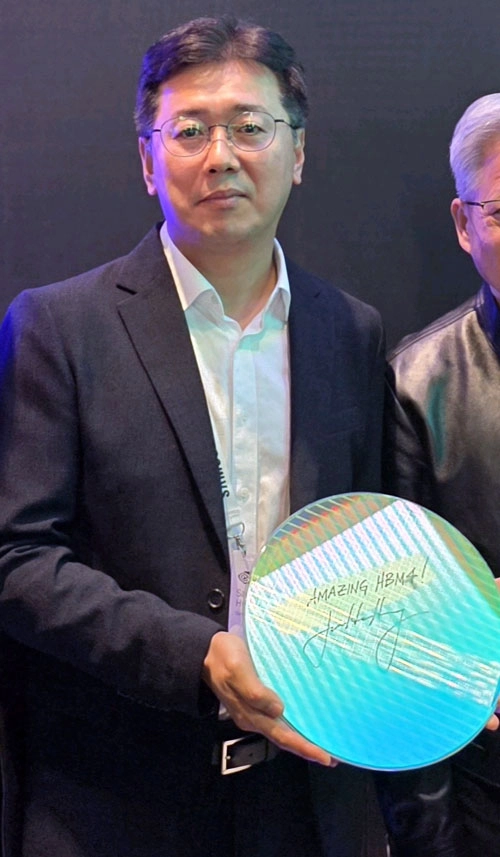 ‘어메이징 HBM4!’  황상준 삼성전자 메모리개발담당 부사장이 16일(현지시간) 미국 새너제이에서 열린 엔비디아의 연례 개발자 콘퍼런스(GTC 2026)의 삼성전자 전시장에서 젠슨 황 엔비디아 최고경영자(CEO)가 ‘어메이징 HBM4!’라고 친필 서명을 한 6세대 고대역폭메모리 HBM4 웨이퍼를 들고 기념 촬영을 하고 있다.
삼성전자 제공