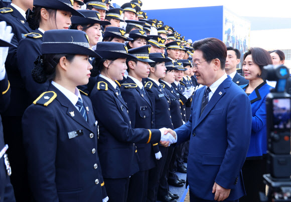 이재명 대통령이 17일 충남 아산 경찰대학에서 경위·경감 합동임용식을 마친 신임 경찰관들과 인사하고 있다. 2026.3.17 연합뉴스