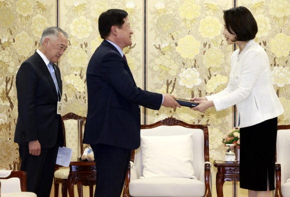 김혜경 여사가 18일 청와대에서 박상철 국제백신연구소(IVI) 한국후원회장으로부터 명예회장 추대패를 받고 있다.  왼쪽은 제롬 김 IVI 사무총장. 2026.3.18 청와대통신사진기자단