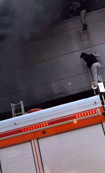 20일 오후 대전 대덕구 문평동 한 자동차부품 제조 공장에서 불이 나 검은 연기가 치솟는 가운데 직원들이 필사적으로 탈출하고 있다.  2026.3.20  독자 김영수 씨 제공