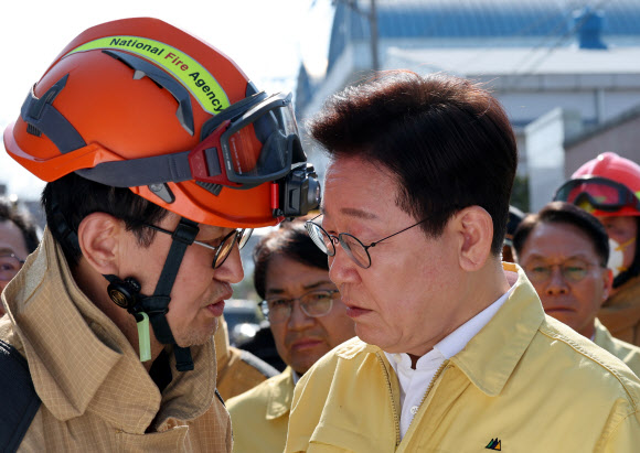이재명 대통령이 21일 대전 대덕구 안전공업 건물의 대형 화재 현장을 찾아 상황보고를 받고 있다.  2026.3.21  [공동취재] 연합뉴스