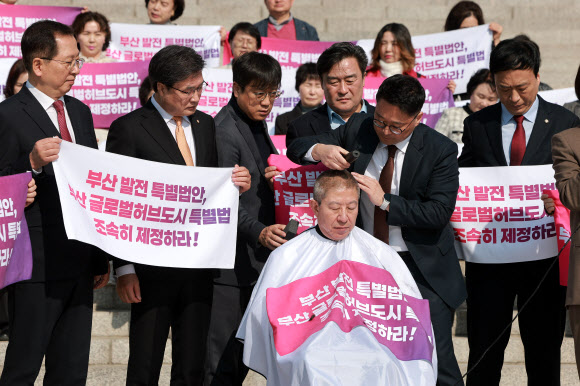 박형준 부산시장이 23일 국회 본청 앞 계단에서 부산 글로벌 허브도시 특별법 제정을 촉구하며 삭발하고 있다. 2026.3.23 연합뉴스