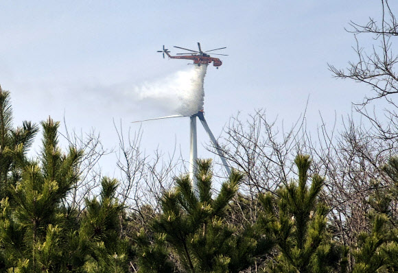 23일 오후 1시 11분께 경북 영덕군 영덕읍 창포리 풍력발전단지 내 한 풍력발전기에서 불이 난 가운데 현장에서 헬기가 진화작업을 하고 있다. 2026.3.23 연합뉴스