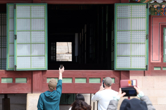 24일 서울 종로구 창덕궁에서 관람객들이 내부를 들여다보고 있다. 창덕궁 전각의 창호를 개방하는 ‘창덕궁 빛·바람 들이기’ 행사는 오는 4월 5일까지 진행한다. 2026.3.24  연합뉴스