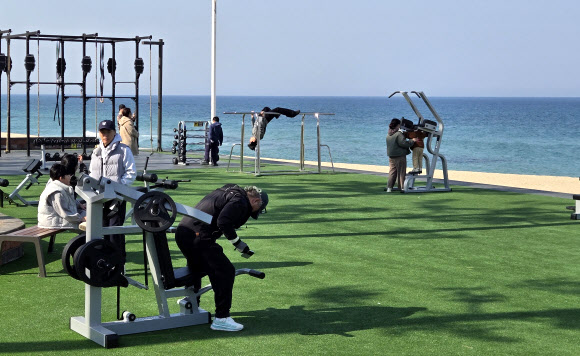 24일 강원 강릉시 사근진해변의 ‘오션 짐’에서 주민과 관광객들이 바다를 보며 운동하고 있다. 2026.3.24  연합뉴스
