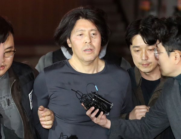 부산 부산진구 소재 아파트에서 전 직장 동료였던 항공사 기장을 살해한 혐의로 구속된 김동환(49)의 신상정보가 24일 공개됐다.  부산경찰청은 이날 신상정보공개심의위원회(위원회)를 열고 김 씨의 얼굴, 이름 등 신상을 공개하기로 했다.  사진은 김동환이 지난 17일 오후 울산에서 검거돼 부산진경찰서로 압송되는 모습.  2026.3.24 뉴스1