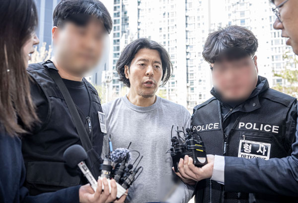 부산 부산진구 소재 아파트에서 전 직장 동료였던 항공사 기장을 살해한 혐의로 구속된 김동환(49)의 신상정보가 24일 공개됐다.  부산경찰청은 이날 신상정보공개심의위원회(위원회)를 열고 김 씨의 얼굴, 이름 등 신상을 공개하기로 했다.  사진은 김동환이 지난 20일 오후 부산 연제구 부산지방법원에서 열린 구속 전 피의자 심문(영장실질심사)에 출석하기 위해 부산지방검찰청으로 들어서는 모습.  2026.3.24 공동취재