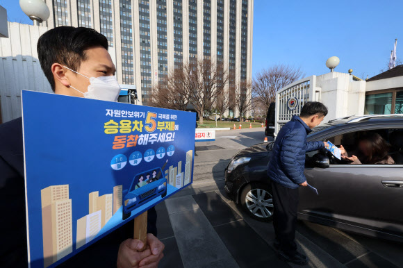 25일 서울 종로구 정부서울청사 입구에서 청사관리소 관계자들이 승용차 5부제 동참 캠페인을 하고 있다. 2026.3.25  연합뉴스
