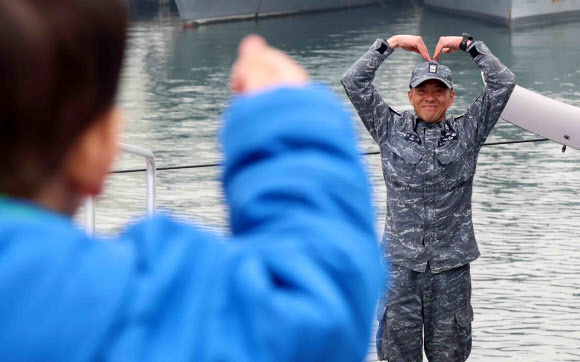 25일 경남 창원시 진해구 해군기지에서 열린 ‘도산안창호함(SS-Ⅲ) 한국·캐나다 연합협력훈련 출항 환송 행사’에서 승조원이 가족에게 손으로 만든 하트를 하고 있다.  3천t급 잠수함 1번함인 도산안창호함은 오는 6월 예정된 한국?캐나다 해군 연합협력훈련 참가를 위해 대한민국 잠수함 최초로 태평양을 횡단한다. 이날 진해기지에서 출항해 캐나다 서부 빅토리아까지 편도 약 1만4천㎞를 항해한다. 이는 우리나라 잠수함 항해 거리로 역대 최장 기록이다. 2026.3.25  연합뉴스