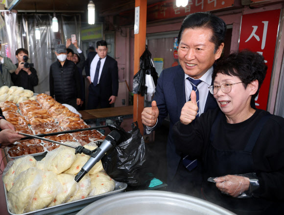 더불어민주당 정청래 대표가 25일 충북 충주시 재래시장인 자유시장을 방문, 찐빵을 구매한 뒤 상인과 기념 촬영을 하고 있다. 2026.3.25  연합뉴스