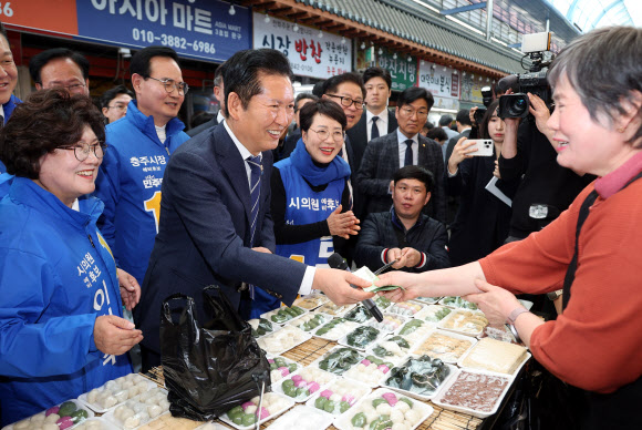 더불어민주당 정청래 대표가 25일 충북 충주시 재래시장인 자유시장을 방문, 떡을 구매하고 있다. 2026.3.25  연합뉴스