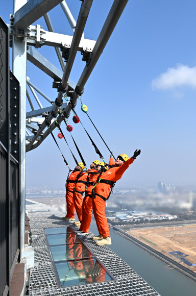 세계 최고 높이 해상교량 전망대인 인천 청라하늘대교(제3연륙교) 전망대의 다음 달 개장을 앞두고 25일 실시된 시설 점검에서 관계자들이 안전 장비를 착용하고 밑이 내려다보이는 외부 공간을 걷는 ‘엣지워크’를 시연하고 있다.  해발 184.2m 높이의 청라하늘대교 주탑 전망대는 ‘세계 최고 높이 해상교량 전망대’로 기네스북에 등재됐으며, 미국 세계기록위원회(WRC)의 인증을 받았다.  시설 이용료는 전망대 1만5천원, 엣지워크(전망대 포함) 6만원으로 인천시민에게는 50% 할인 혜택이 제공된다. 2026.3.25  공동취재