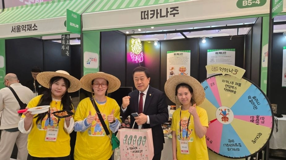 지난 26일 동대문디자인플라자(DDP)에서 개최된 ‘2026 소상공인 힘보탬 박람회’에 참석한 김용호 서울시의원(오른쪽 두 번째)이 용산구에서 가게를 운영하고 있는 떠카나주 매장에서 제품을 구매한 후 직원들과 기념촬영을 하고 있다.
