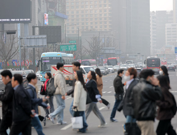 미세먼지 농도가 ‘나쁨’ 수준을 보이는 27일 서울 광화문 세종대로 사거리에서 시민들이 마스크를 쓴 채 걸어가고 있다. 2026.3.27 연합뉴스