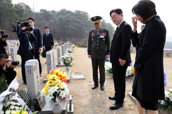 이재명 대통령과 김혜경 여사가 27일 국립대전현충원에서 서해수호의 날 기념식 전 채수근 상병의 묘역을 살펴보고 있다. 왼쪽은 주일석 해병대사령관. 2026.3.27 청와대통신사진기자단
