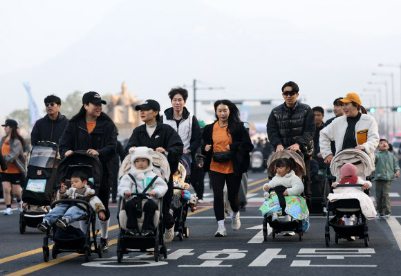 28일 서울 종로구 광화문광장에서 열린 2026 서울 유아차 런(Run) 행사에 참가한 부모들이 유아차를 밀며 달리고 있다. 2026.3.28  연합뉴스