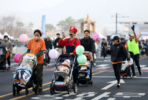 28일 서울 종로구 광화문광장에서 열린 2026 서울 유아차 런(Run) 행사에 참가한 부모들이 유아차를 밀며 달리고 있다. 2026.3.28  연합뉴스