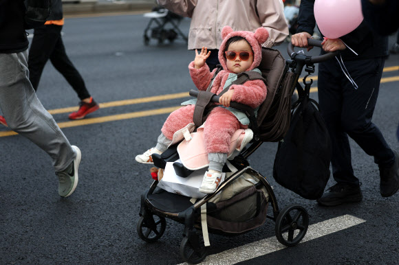28일 서울 종로구 광화문광장에서 열린 2026 서울 유아차 런(Run) 행사에 참가한 어린이가 손을 흔들고 있다. 2026.3.28  연합뉴스