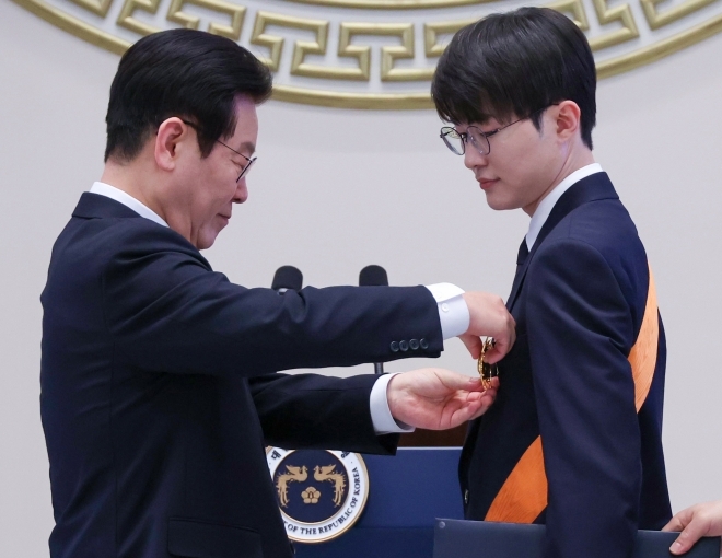 이재명 대통령이 2일 청와대 영빈관에서 열린 신년 인사회에서 프로게이머 ‘페이커’ 이상혁 선수에게 ‘청룡장’ 훈장을 수여하고 있다. 2026.1.2 연합뉴스