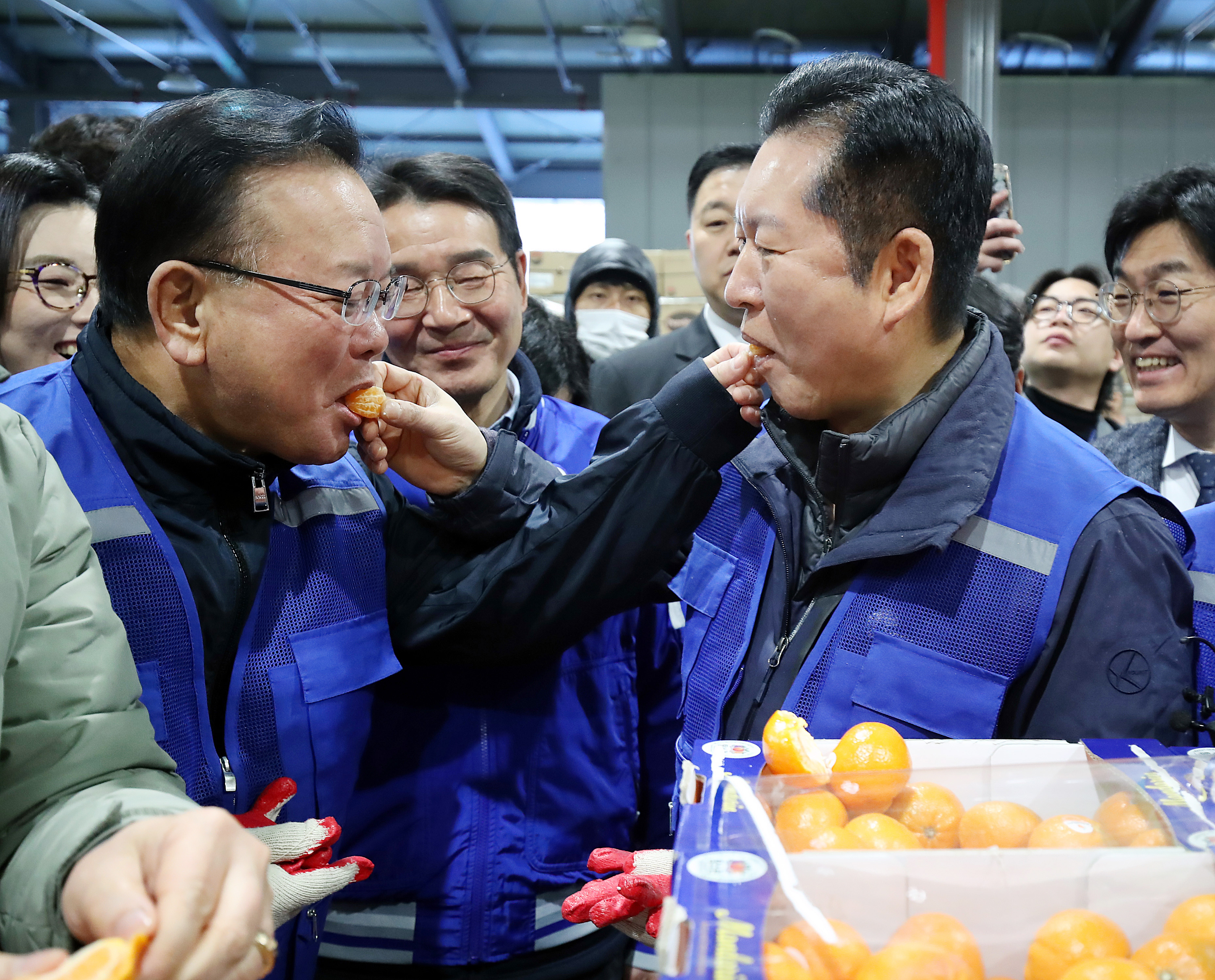 8일 오전 대구 북구 대구농수산물도매시장에서 민생 현장 체험에 나선 정청래 더불어민주당 대표와 대구시장 선거에 출마한 김부겸 전 총리가 경매사의 안내를 받아 경매에서 낙찰된 수입산 감귤을 맛보고 있다.  2026.4.8. 뉴스1