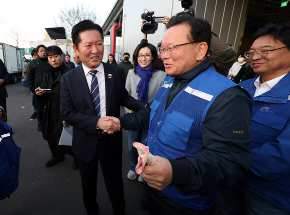 더불어민주당 정청래 대표와 민주당의 대구시장 후보로 확정된 김부겸 전 총리가 8일 오전 대구 북구 매천동 농수산물도매시장에서 민생현장을 살피기에 앞서 악수하며 인사를 나누고 있다. 2026.4.8 연합뉴스