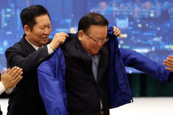 더불어민주당 정청래 대표가 8일 대구 북구 인터불고 엑스코 호텔에서 열린 더불어민주당 현장 최고위원회의에서 대구시장 후보인 김부겸 전 국무총리에게 당 점퍼를 입혀주고 있다. 2026.4.8 연합뉴스