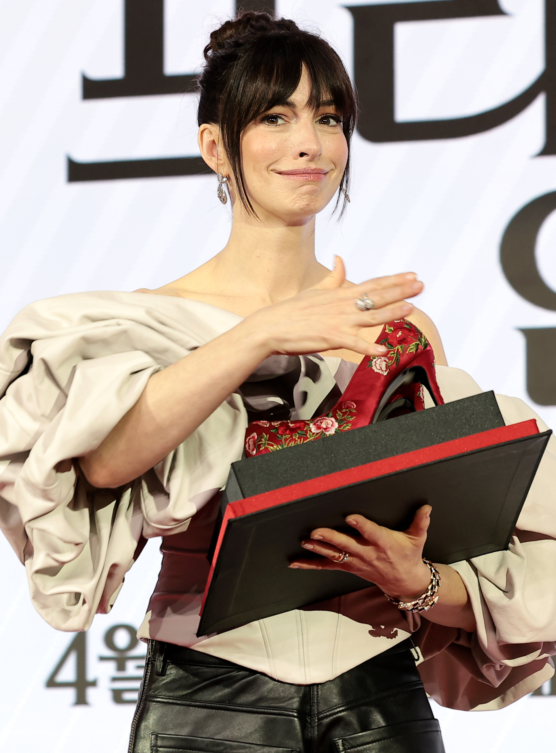 배우 앤 해서웨이가 8일 서울 종로구 포시즌스 호텔 서울에서 열린 영화 ‘악마는 프라다를 입는다 2’(감독 데이빗 프랭클) 내한 기자간담회에서 꽃신을 선물 받고 행복한 표정을 짓고 있다. 2026.4.8. 뉴스1