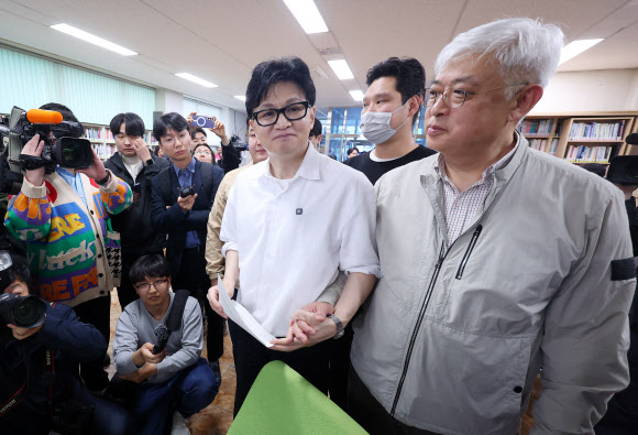 한동훈 전 국민의힘 대표가 14일 오후 부산 북구 만덕2동 행정복지센터를 찾아 전입신고를 하고 있다. 오른쪽은 한 전 대표가 이사한 아파트 이웃 주민. 2026.4.14 연합뉴스