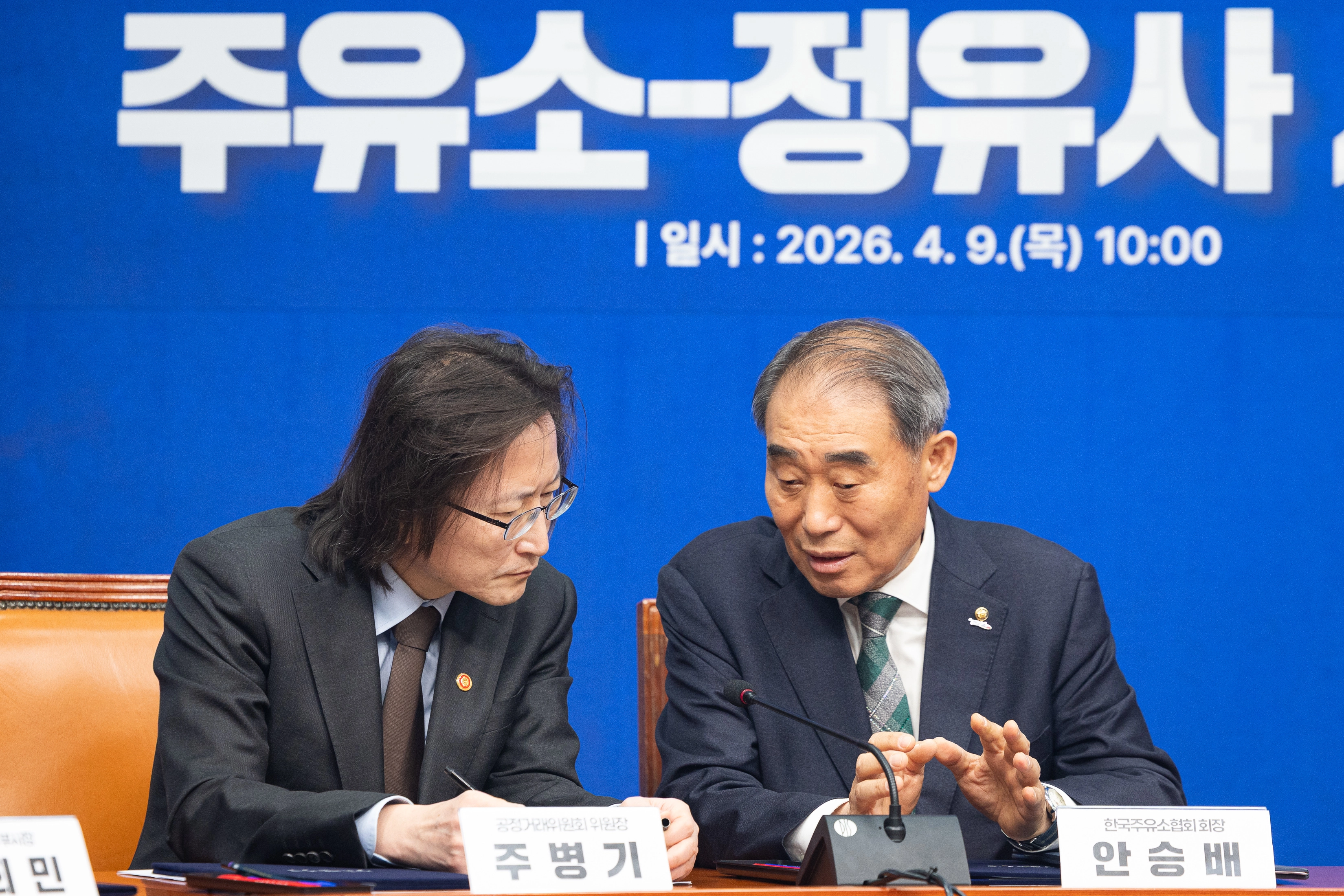 대화 나누는 주병기 공정위원장과 안승배 한국주유소협회장  (서울=뉴스1) 유승관 기자 = 주병기 공정거래위원장과 안승배 한국주유소협회장이 9일 서울 여의도 국회에서 열린 더불어민주당 중동전쟁 위기 극복을 위한 고통분담 ‘주유소-정유사 사회적대화 상생협약식’에서 대화하고 있다. 2026.4.9/뉴스1