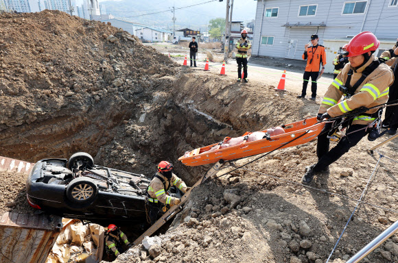 15일 경기도 하남시 천현동 교산 공공주택지구 공사 현장에서 열린 ‘2026년 중대재난대응 유관기관 합동훈련’에서 소방관들이 싱크홀 발생으로 인한 차량 매몰 상황 등을 가정한 인명 구조훈련을 하고 있다. 2026.4.15  연합뉴스
