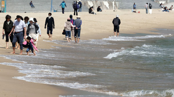 전국적으로 초여름 날씨를 보인 15일 부산 해운대구 해운대해수욕장을 찾은 외국인들이 일광욕을 즐기고 있다. 2026.04.15. 뉴시스