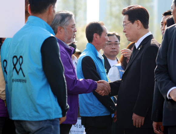 이재명 대통령이 16일 경기도 안산 화랑유원지에서 열린 세월호 참사 12주기 기억식 후 이정민 10·29 이태원참사 유가족협의회 운영위원장과 인사하고 있다. 2026.4.16 연합뉴스