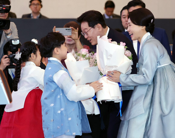 베트남을 국빈 방문 중인 이재명 대통령과 김혜경 여사가 22일(현지시간) 하노이의 한 호텔에서 열린 동포간담회에서 화동으로부터 꽃다발을 받고 있다. 2026.4.22 연합뉴스