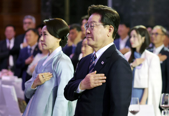 베트남을 국빈 방문 중인 이재명 대통령과 김혜경 여사가 22일(현지시간) 하노이의 한 호텔에서 열린 동포간담회에서 국기에 경례하고 있다. 2026.4.22 연합뉴스