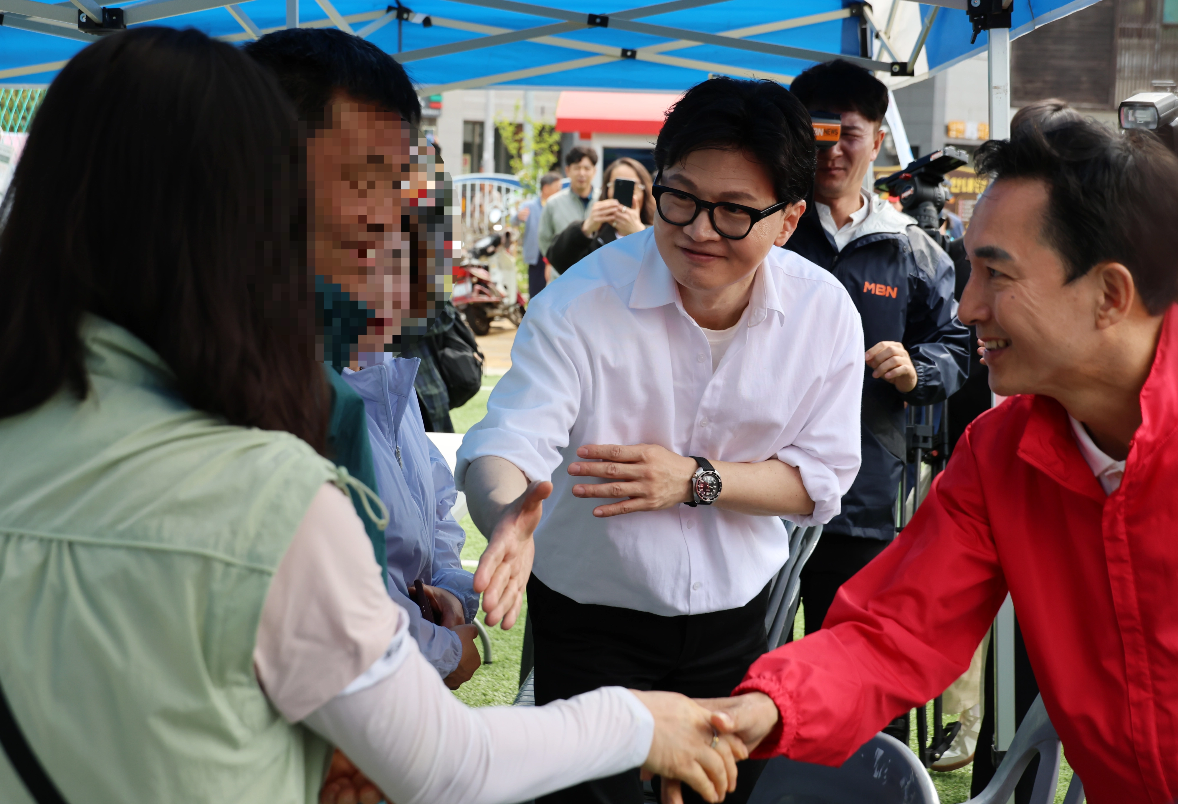시선은 따로  부산 북갑 국회의원 보궐선거에서 국민의힘 공천을 바라는 박민식 전 국가보훈부 장관과 무속소 출마를 공식화 한 한동훈 전 국민의힘 대표가 26일 부산 구포초에서 열린 동문회 운동회에서 주민에게 인사를 하고 있다. 2026.4.26 연합뉴스