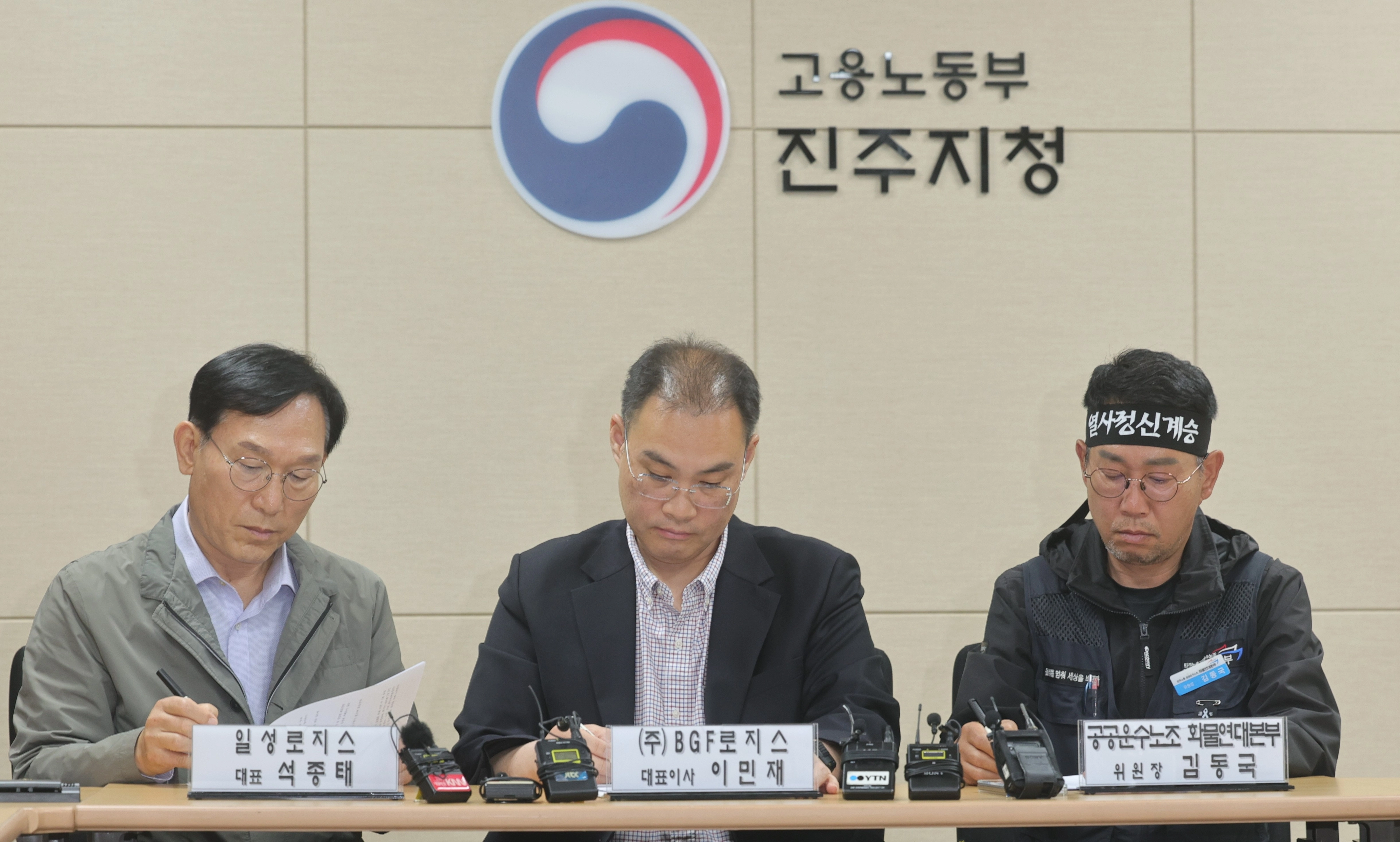 민주노총 공공운수노조 화물연대본부(화물연대) 김동국 위원장(맨 오른쪽)과 이민재 BGF 로지스 대표이사(가운데), 석종태 일성로지스 대표가 30일 오전 경남 진주시 고용노동부 진주지청에서 단체합의서에 서명하고 있다. 연합뉴스