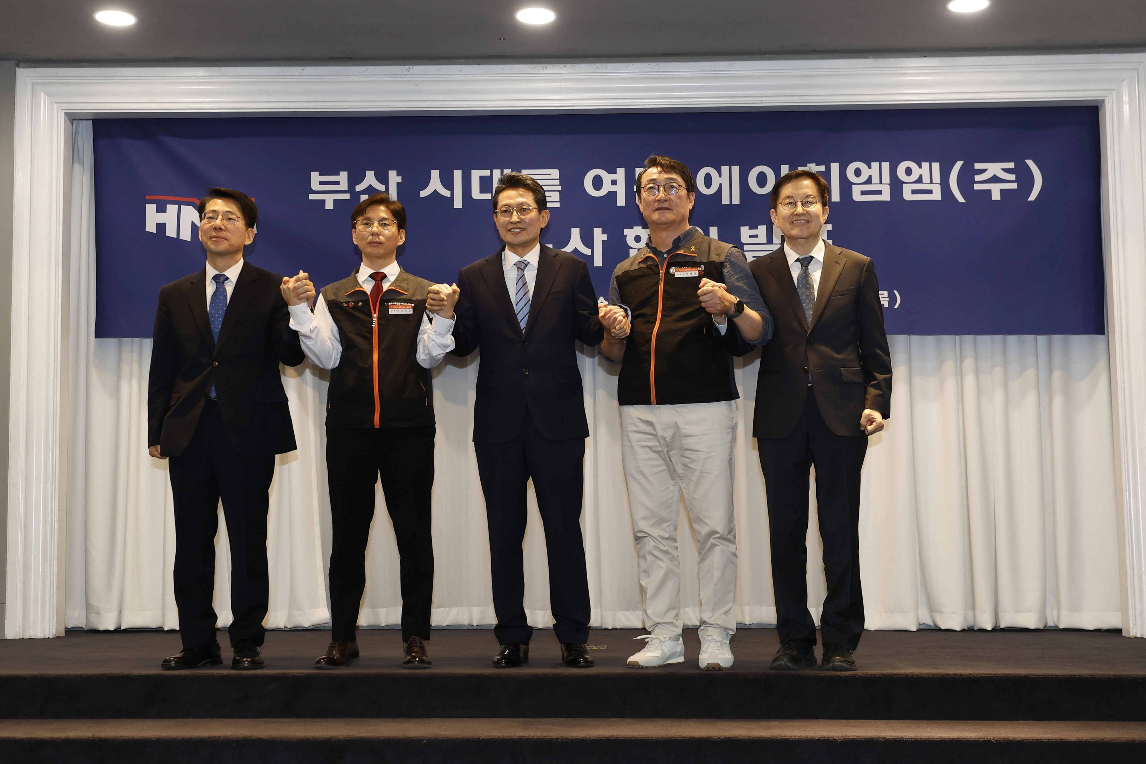 HMM노사가 30일 서울 영등포구 여의도 켄싱턴호텔에서 본사 부산 이전 노사합의서 서명식을 가진 뒤 기념 촬영을 하고 있다.  왼쪽부터 황종우 해양수산부 장관, 정성철 HMM육상노조 지부장, 최원혁 HMM 대표이사 사장, 이재진 사무금융서비스노조 위원장, 김형준 한국해양진흥공사 본부장.
HMM 제공