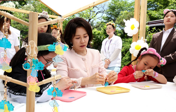 김혜경 여사가 5일 청와대 녹지원에서 열린 어린이날 초청행사에서 참석 어린이들과 함께 열쇠고리 만들기 체험을 하고 있다. 2026.5.5. 청와대통신사진기자단