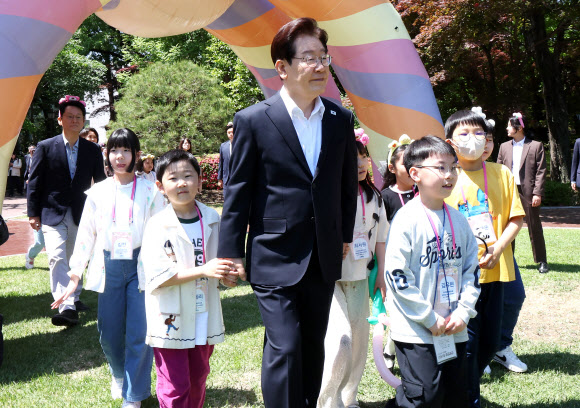 이재명 대통령이 5일 어린이날 초청행사 참석자들과 함께 청와대 녹지원으로 향하고 있다. 2026.5.5. 청와대통신사진기자단