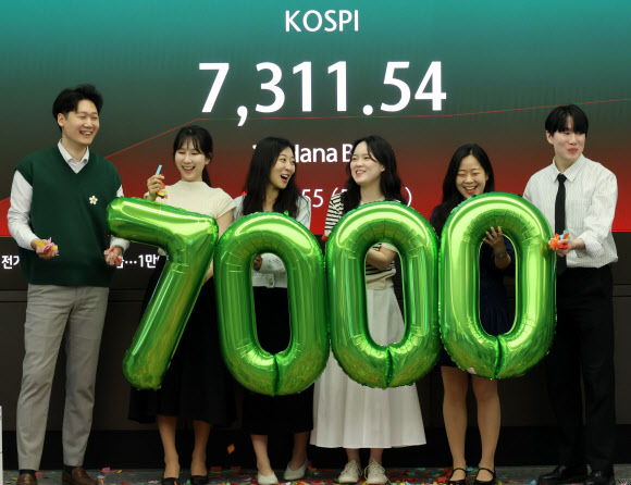 코스피가 7000을 돌파한 6일 서울 중구 하나은행 본점 딜링룸에서 직원들이 축하 세리머니를 하고 있다. 2026.5.6  연합뉴스