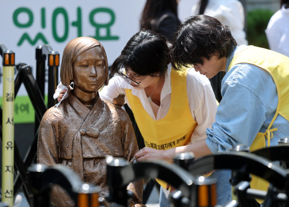 6일 서울 종로구 옛 주한 일본대사관 인근에서 열린 ‘일본군 성노예제 문제해결을 위한 정기 수요시위’에 앞서 관계자들이 소녀상을 닦고 있다. 2026.5.6  연합뉴스