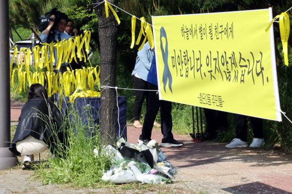 7일 여고생 흉기 살인사건이 발생한 광주 광산구 월계동 추모 현장에서 행정복지센터 직원들이 주변을 정리하고 있다.2026.5.7 연합뉴스